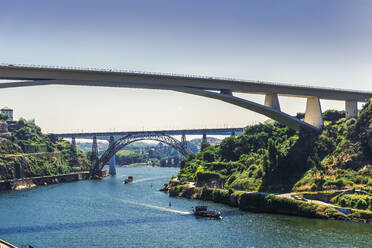 Blick auf drei Brücken über den Fluss Douro mit Touristenschiffen vor den Brücken Infante D. Henrique, Maria Pia und St. John, Porto, Portugal, Europa - RHPLF11702