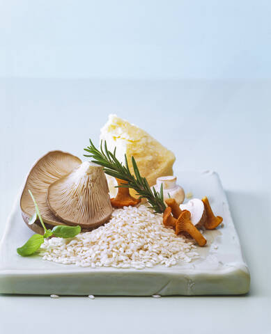 Nahaufnahme von rohen Zutaten für die Zubereitung von Risotto auf einem Tisch an der Wand, lizenzfreies Stockfoto