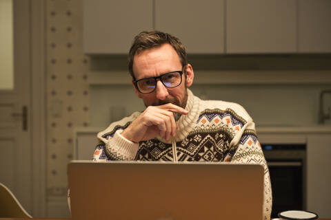 Casual businessman using laptop on table at home stock photo