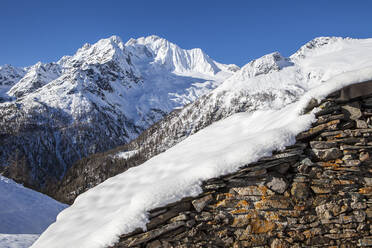 Steinhütte mit Schnee bedeckt mit Monte Disgrazia im Hintergrund, Alpe dell'Oro, Valmalenco, Valtellina, Lombardei, Italien, Europa - RHPLF11789