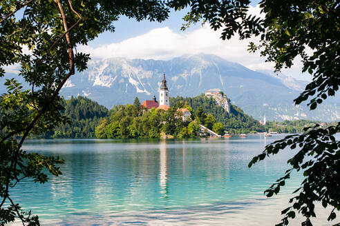 Winzige Insel mit einer Kirche, einem Schloss auf einem Felsen und Blick auf die Berge, Bleder See, Slowenien, Europa - RHPLF11809