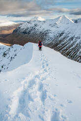 A female walker descending from the summit of Stob Dubh on Buchaille Etive Beag on a crisp winter day, Highlands, Scotland, United Kingdom, Europe - RHPLF11823