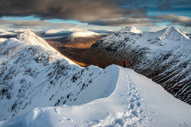 Eine Wanderin nähert sich dem Gipfel des Stob Dubh auf Buchaille Etive Beag an einem klaren Wintertag, Highlands, Schottland, Vereinigtes Königreich, Europa - RHPLF11824