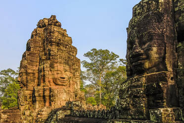 Towers and three of the 216 smiling sandstone faces at 12th century Bayon temple in Angkor Thom walled city, Angkor, UNESCO World Heritage Site, Siem Reap, Cambodia, Indochina, Southeast Asia, Asia - RHPLF11850