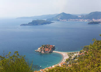 Blick von einem Hügel auf die Bucht von Budva und den exklusiven Inselort Sveti Stefan, Budva, Montenegro, Europa - RHPLF11942