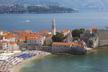 Blick über den überfüllten Strand auf die Altstadt (Stari Grad) und die Bucht von Budva, Budva, Montenegro, Europa - RHPLF11945