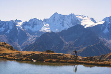 Mountain trekker in autumn season in Stelvio National Park in Brescia Province, Lombard, Italy, Europe - RHPLF12039