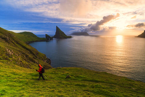 Trekker on the hiking trail to Drangarnir rock, Vagar island, Faroe Islands, Denmark, Europe - RHPLF12096