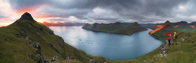 Panorama von Wanderern auf Klippen mit Blick auf die Fjorde, Funningur, Insel Eysturoy, Färöer Inseln, Dänemark, Europa - RHPLF12102