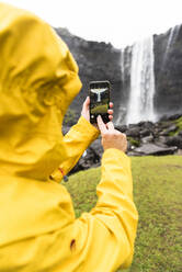 Tourist knipst Fotos mit Smartphone, Wasserfall Fossa, Insel Streymoy, Färöer, Dänemark, Europa - RHPLF12116