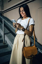 Young woman using smartphone in the city at night - OYF00085