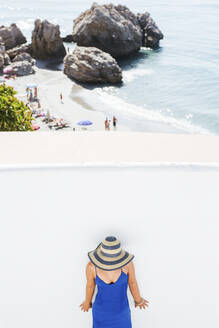 Frau in blauem Kleid und Strohhut vor einer weißen Wand, Nerja, Spanien - LJF00991