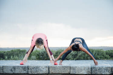 Woman teaching yoga to senior woman - OCMF00730