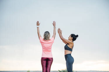 Woman teaching yoga to senior woman - OCMF00731