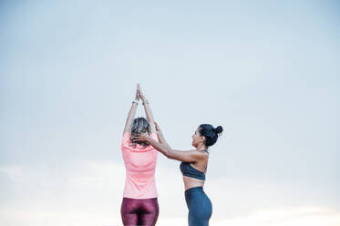 Woman teaching yoga to senior woman - OCMF00732