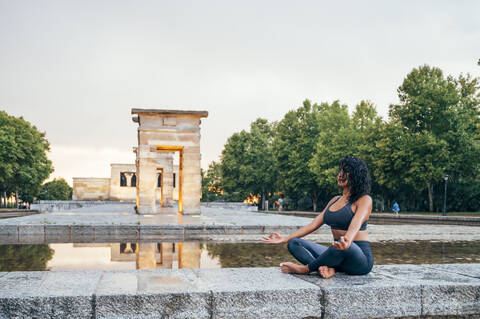 Woman practicing yoga after rain stock photo