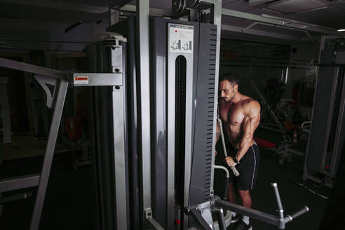 Muskulöser Mann beim Training im Fitnessstudio - LJF00996