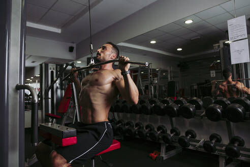 Muskulöser Mann beim Training im Fitnessstudio - LJF00998