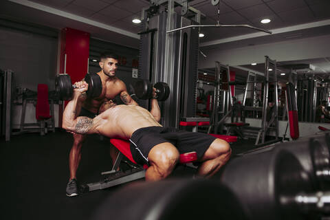 Muskulöse Männer trainieren im Fitnessstudio, lizenzfreies Stockfoto