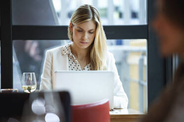 Geschäftsfrau mit Laptop in einem Restaurant - JSRF00616