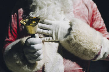 Hand des Weihnachtsmanns, der eine Handglocke hält, Nahaufnahme - OCMF00758
