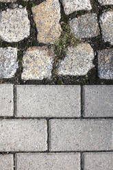 Old and new cobblestones, with grass growing in between - JTF01351