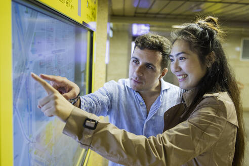 Couple checking map at Ginza underground station, Tokyo, Japan - MCVF00034