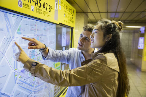Pärchen bei der Kartenkontrolle in der U-Bahn-Station Ginza, Tokio, Japan - MCVF00035
