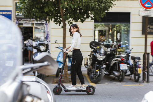 Junge Frau mit E-Scooter in der Stadt - LJF01032