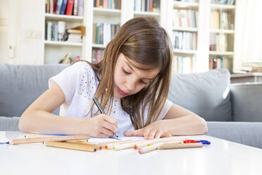 Portrait of girl drawing with coloured pencil at home - LVF08268