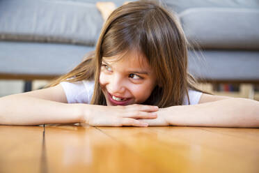 Porträt eines lachenden Mädchens, das zu Hause auf dem Boden liegt - LVF08270