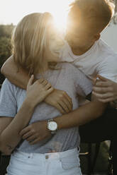 Young couple on a climbing frame at sunset - LHPF00850