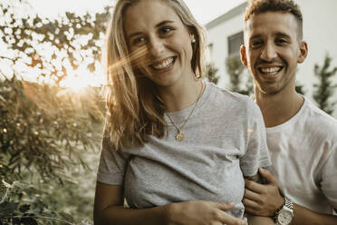 Porträt eines jungen lächelnden Paares bei Sonnenuntergang - LHPF00855