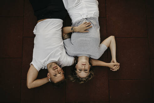 Junges Paar auf dem Boden liegend, von oben - LHPF00863