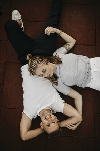 Junges Paar auf dem Boden liegend, von oben, lizenzfreies Stockfoto
