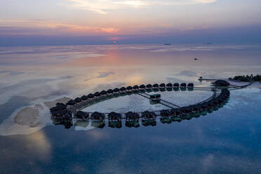 Luftaufnahme der Stelzenhäuser auf der Insel Olhuveli bei Sonnenaufgang auf den Malediven - AMF07300