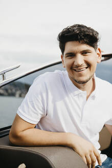 Porträt eines glücklichen Mannes bei einer Bootsfahrt auf einem See - LHPF00884