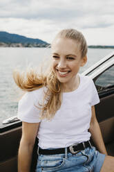 Glückliche junge Frau bei einer Bootsfahrt auf einem See - LHPF00889