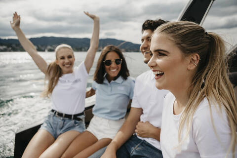 Glückliche Freunde bei einer Bootsfahrt auf einem See, lizenzfreies Stockfoto