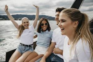 Happy friends on a boat trip on a lake - LHPF00897