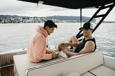 Happy friends on a boat trip on a lake - LHPF00903