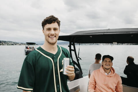 Happy friends having a drink on a boat trip on a lake stock photo