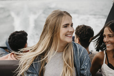 Happy friends on a boat trip on a lake stock photo