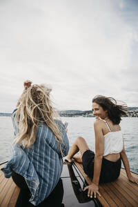 Happy female friends on a boat trip on a lake - LHPF00926