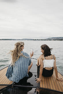 Glückliche Freundinnen bei einem Bootsausflug auf einem See - LHPF00927