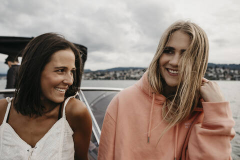 Happy female friends on a boat trip on a lake stock photo