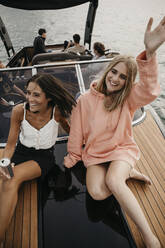 Happy friends on a boat trip on a lake - LHPF00931