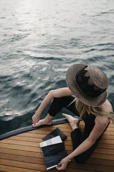 Frau mit einem Buch auf einem Boot - LHPF00935