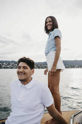 Happy young couple on a boat trip on a lake - LHPF00937