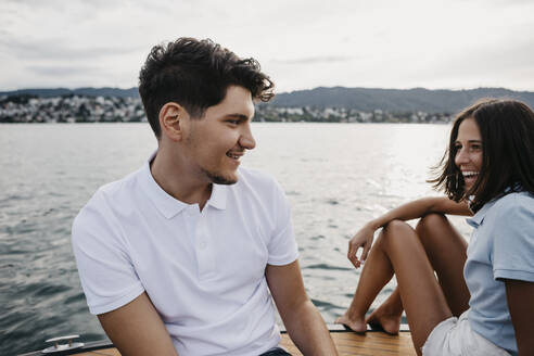 Glückliches junges Paar bei einer Bootsfahrt auf einem See - LHPF00938